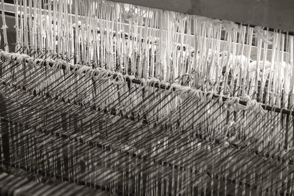 A traditional weaving loom strung with colored threads